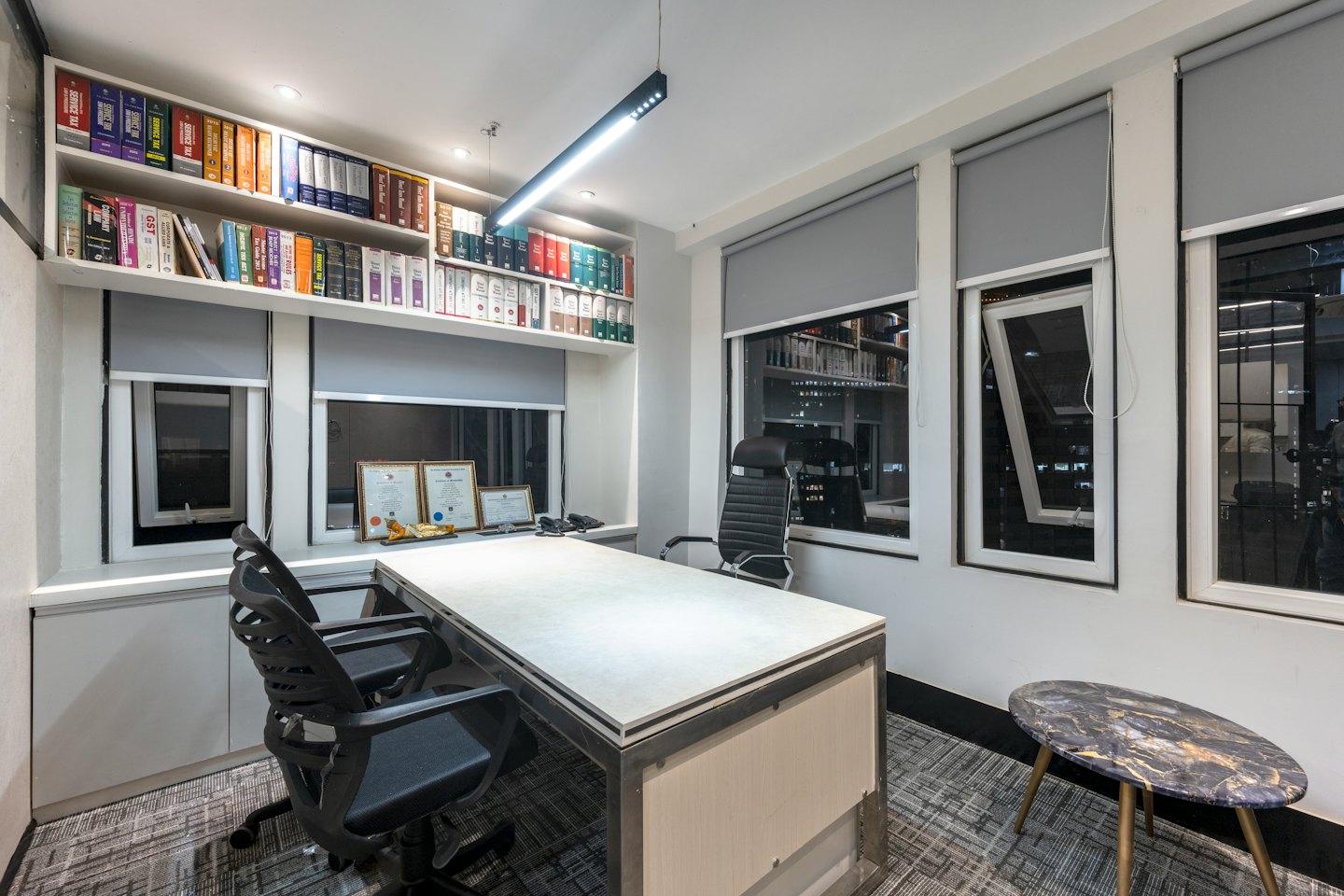 Kantor profesional dengan meja besar dan rak buku perpustakaan hukum.
